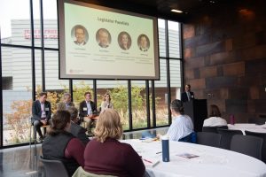 Four legislatures sitting at the front of a room during a panel discussion.